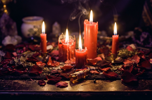 Candle love spell setup with lit red candles, rose petals, and herbs creating a magical ambiance.
