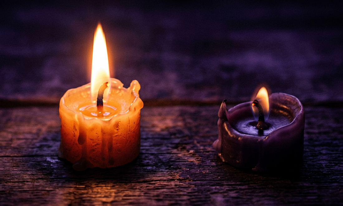 A hot and cold relationship dynamic symbolized by two candles: one tall yellow candle burning bright with a high flame. dating